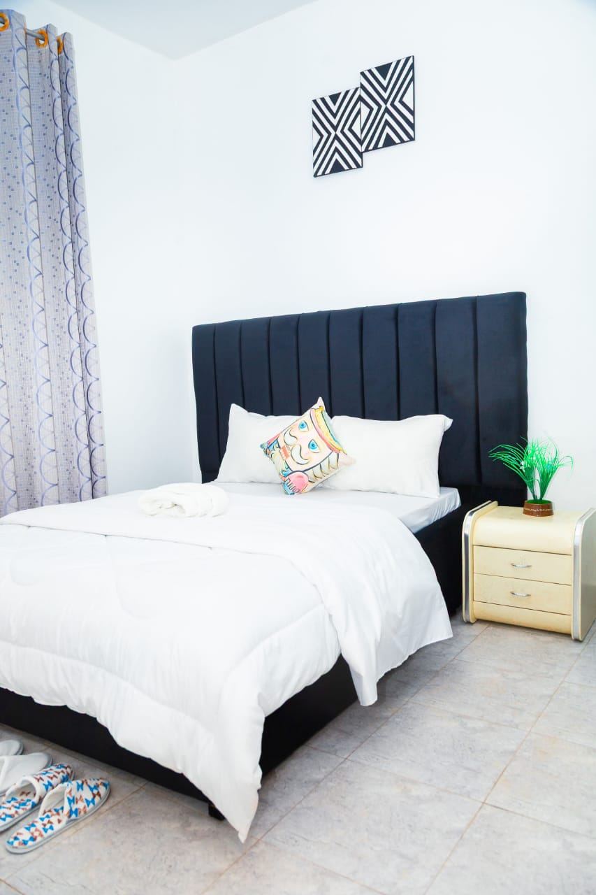 Bedroom with black headboard and orange towels